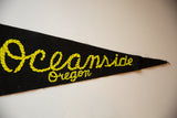 Yellow rope design of 'Oceanside Oregon' lettering on black vintage felt.