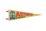 Vintage yellow felt Astoria Oregon pennant with red text and colorful column graphic.