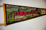 Vintage Oregon felt pennant showing glittered Pacific Seacoast scene and red OREGON letters.