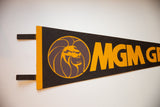 Black felt vintage pennant with bold orange 'MGM G' lettering.