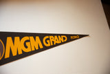 Pointed end of vintage MGM Grand Reno felt pennant, displaying orange lettering.