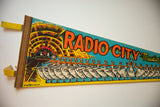 Vintage Radio City Music Hall felt flag left edge, yellow hanging tabs, dancing ballerinas.