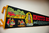 Angled view of a vintage Knotts Berry Farm pennant with colorful retro graphics.