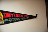 Angled view of the retro red and light blue text on the black felt pennant.