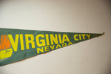 Vintage Virginia City Nevada felt pennant with yellow text, teal felt, and worn pointed tip.