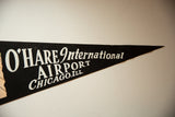 Black felt vintage O'Hare Airport pennant showing white 'International Airport CHICAGO.ILL.' text.