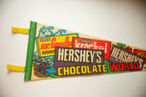 Vintage Hershey's Chocolate World felt flag, featuring brown and yellow text with retro candy wrappers.
