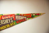 Close-up of vintage Hershey's Chocolate World felt flag with Reese's and Rally logos.