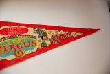 Vintage felt pennant with circus elephant, striped tents, and yellow stars.