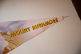Gold outlined lettering on the pointed tip of the vintage Mount Rushmore felt flag.