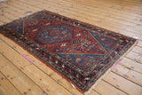 Vintage Hamadan rug corner with sapphire blue spandrel, intricate border, and fringe.