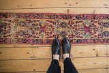 Intricate blossom and thousand flower design on antique Kerman runner's pale apricot field.