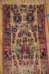 Intricate Kerman floral motifs in cochineal red, navy, apricot, showing even wear.