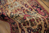 Intricate cochineal red and apricot floral petals on hand-knotted antique Kerman runner pile.