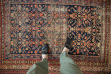 Vintage Malayer rug with Herati design, navy, red, ivory, and prominent textured wear.