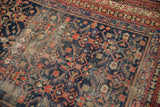 Worn Herati design on a vintage Malayer rug, showing navy, red motifs and exposed foundation.