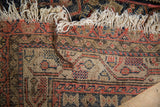 Vintage Malayer rug's woven foundation, showing its muted pattern and tattered fringe.