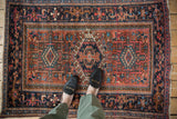 Vintage Karaja rug corner, showing navy Samovar border and geometric motifs in madder red, teal.