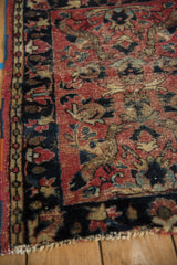 Vintage Persian Lilihan rug with faded brick red field, navy floral motifs, and visible foundation.