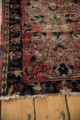 Vintage Lilihan rug corner: faded brick red ground, large floral motifs, visible foundation.