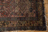 Vintage Mehreban rug corner, with visible wear to pile, frayed edge and blue border.