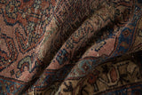 Folded texture of vintage Mehreban rug, showing worn pile with detailed patterns in dusty raspberry and sapphire blue.