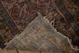 Worn dusty raspberry pile meets hand-knotted foundation on a Vintage Mehreban rug corner.