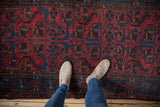 Close-up of vintage Persian Mehreban rug in raspberry red and sapphire blue pinwheel patterns.