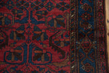 Sapphire blue border and raspberry red field with pinwheel motifs on a vintage Mehreban rug.