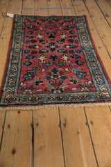 Vintage Lilihan rug showing unique raspberry field minor blossoms and patterned indigo border.
