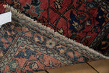 Vintage Lilihan rug's brick red pile, intricate reverse weave, and machine binding.