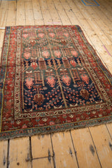 Kurdish Hamadan rug corner with madder red border and navy field featuring blush boteh blossoms.