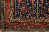 Hand knotted Kurdish Hamadan rug corner showcasing dark madder red, navy, and blush floral borders with fringe.