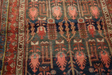 Kurdish Hamadan rug detail: blush finned motifs on a charcoal field with a red border.