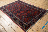 Angled view of a vintage Engelas rug highlighting the wool's soft sheen and rust-red Herati pattern.