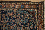 Top right corner of vintage Dargezine rug, showing arabesque spandrel, patterned borders, and fringe.