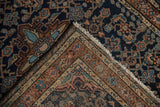 Folded corner of vintage Persian Dargezine rug with Herati, arabesque motifs, and ivory fringe.