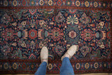 A personal perspective of the vintage Mehreban rug's rich texture and floral pattern underfoot.