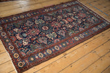 Angled view of a vintage Mehreban rug highlighting its allover floral design and serpent border.