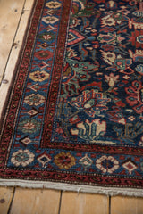 Angled view of the vintage Mehreban rug's detailed floral and serpent borders.