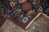 Corner of a vintage Persian Mehreban rug folded to reveal its hand-knotted construction.