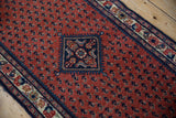 Traditional Engelas rug corner: madder red field of botehs, sapphire Herati medallion, floral border.