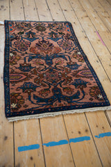 Angled perspective of a vintage Mehreban sampler rug in dusty rose and sapphire blue.