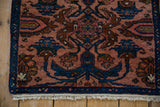 Corner of a vintage Mehreban rug with an indigo border, dusty rose field, and short ivory fringe.