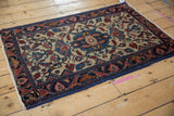 Vintage Lilihan rug corner: dark blue floral border, platinum field, blush vinery, machine binding.