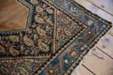 Vintage Hamadan rug edge showing navy field, sand boteh motifs, sky blue border, and selvage.