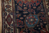 Vintage Hamadan rug detail: ivory border, geometric deep copper and sapphire motifs, textured navy field.