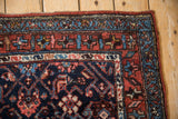 Vintage Kurdish Hamadan rug corner, geometric Herati pattern, navy, madder red, and sky blue.