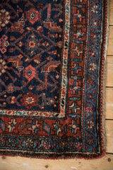 Vintage Kurdish Hamadan rug corner, deep navy and red geometric patterns, short fringe.