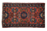 Vintage Lilihan rug with faded brick red field and interconnected blue, green, brown medallions.
